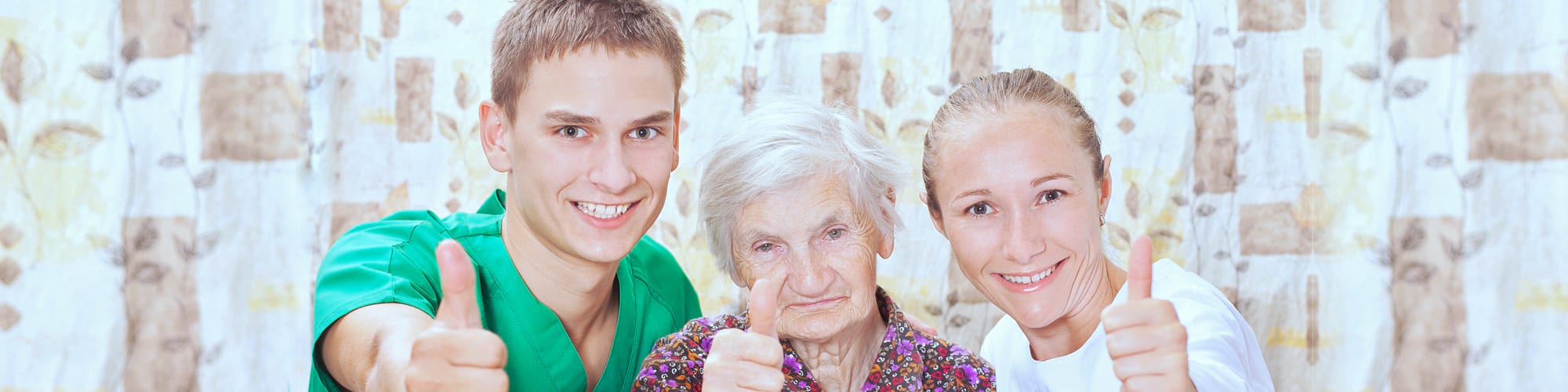 two caregiver and a senior woman smiling